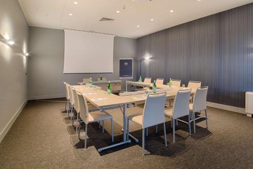 a conference room with a long table and chairs at NH Bologna De La Gare in Bologna