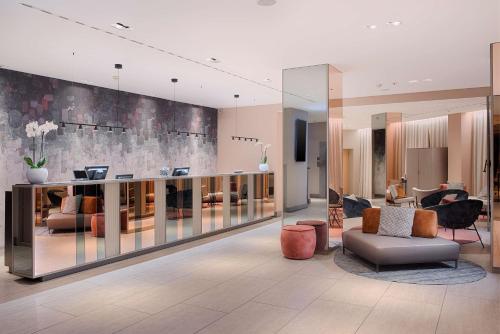 a lobby with a couch and chairs in a building at NH Bologna De La Gare in Bologna