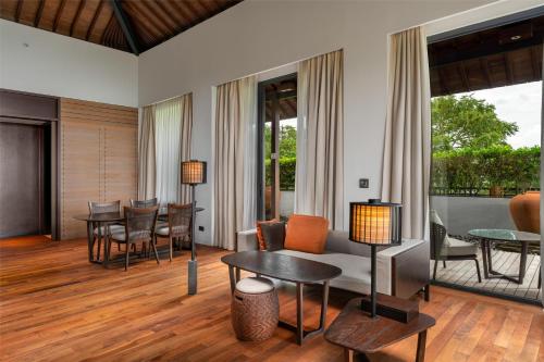 a living room with a couch and tables and chairs at Radisson Blu Bali Uluwatu in Uluwatu