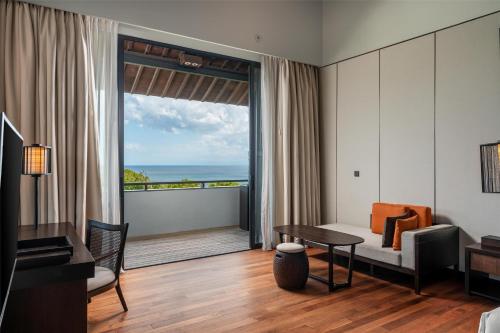 a living room with a view of the ocean at Radisson Blu Bali Uluwatu in Uluwatu