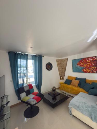 ein Wohnzimmer mit einer Couch und einem Bett in der Unterkunft à 10 minutes Futuroscope in Vendeuvre-du-Poitou