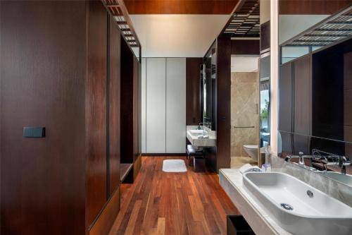 a bathroom with a large tub and a sink at Radisson Blu Bali Uluwatu in Uluwatu