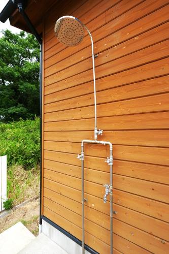 a shower on the side of a wooden wall at The CATAN 久美浜 in Kyotango