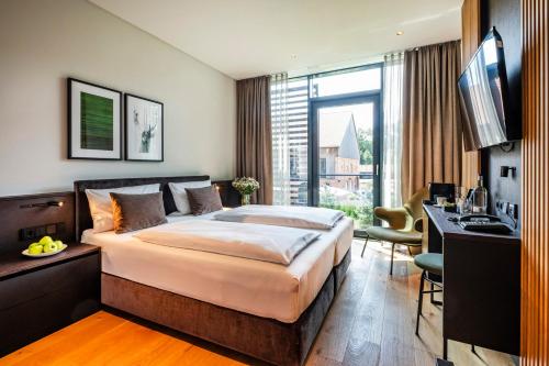 une chambre d'hôtel avec un lit, un bureau et une télévision dans l'établissement Hotel Breitenburg, à Breitenburg