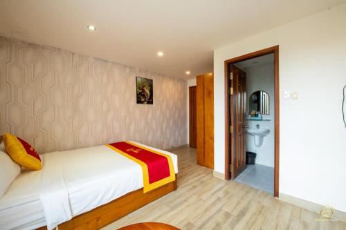 a bedroom with a bed and a bathroom at Monaco Hotel Phú Quốc in Phu Quoc