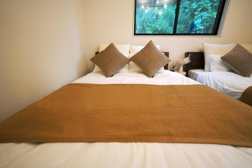 a bedroom with a large bed and a window at The CATAN 久美浜 in Kyotango