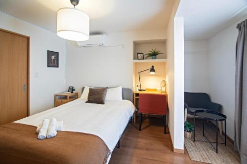een kleine slaapkamer met een bed en een bureau bij Osaka - House - Vacation STAY 16353 in Osaka
