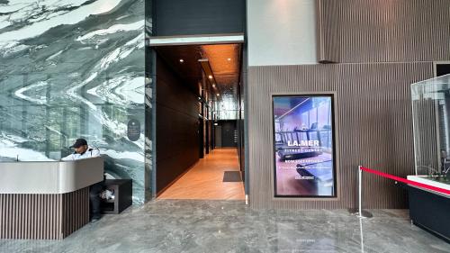 a man sitting at a desk in a lobby with a mural at Luxury, Cosy Seaview 1 bed Suite near SICC, Cuckoo in Kota Kinabalu