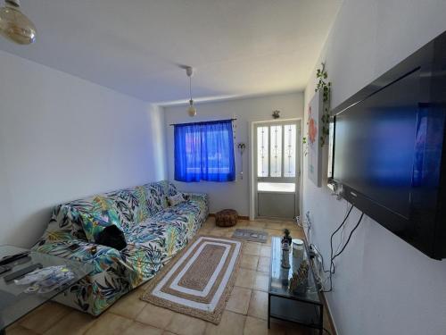 a living room with a couch and a flat screen tv at Traditional Peniche House in Peniche