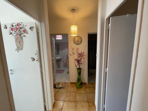 einen Flur mit einer Blumenvase und einer Uhr in der Unterkunft Traditional Peniche House in Peniche