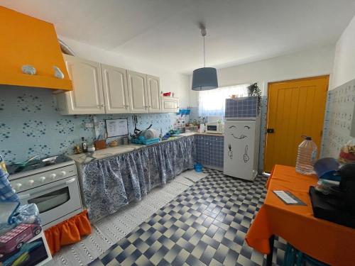 a kitchen with white cabinets and a white refrigerator at Traditional Peniche House in Peniche