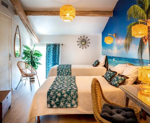 two beds in a room with blue walls at Hotel Toppin in Cavaillon