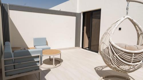 a living room with a swinging chair and a table at فندق روزا جراند غرناطه in Riyadh