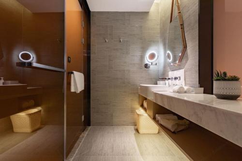 a bathroom with two sinks and a shower at Atour Hotel Zhongshan North Station V-PARK Plaza in Zhongshan