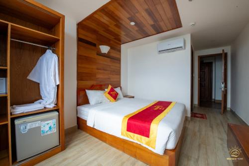 a bedroom with a large bed and a closet at Monaco Hotel Phú Quốc in Phu Quoc