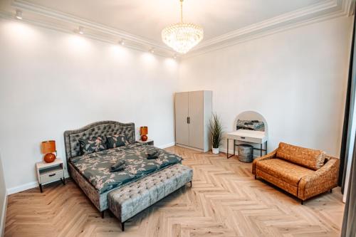 a living room with a bed and a chair at Vārves Muiža in Vārve