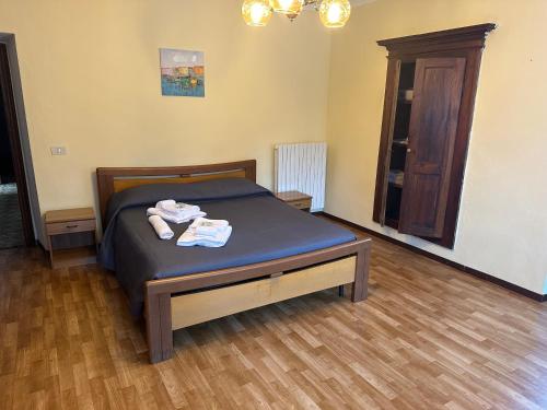 a bedroom with a bed and a wooden floor at Il Camino in Anzino