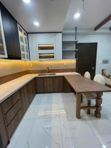 a kitchen with a wooden table and a sink at Căn hộ nghỉ dưỡng Dĩ An in Dĩ An