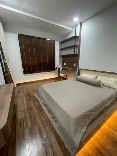a bedroom with a large bed and a large window at Căn hộ nghỉ dưỡng Dĩ An in Dĩ An
