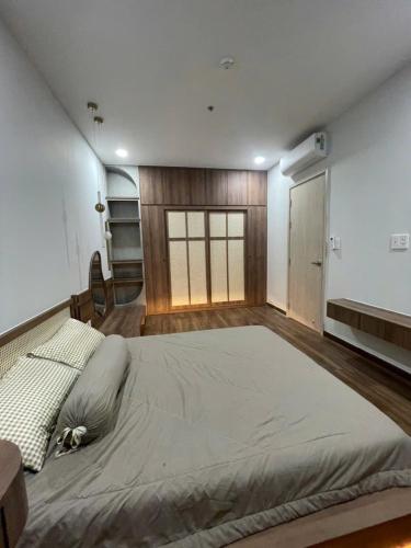 a large bed in a room with wooden floors at Căn hộ nghỉ dưỡng Dĩ An in Dĩ An