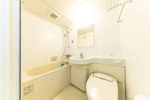 a small bathroom with a toilet and a sink at APA Hotel Kagoshima Chuo Ekimae in Kagoshima