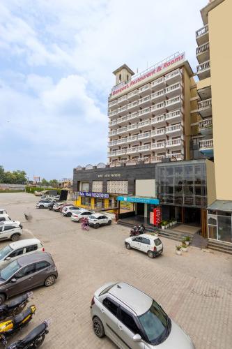 a large building with cars parked in a parking lot at Hotel Lotus Paradise in Rāi