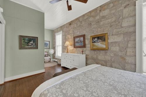 フレデリックスバーグにあるFountain Suite-Stay Right on Historic Main Street in the Heart of Fredericksburgの石壁のベッドルーム1室、ベッド1台が備わります。