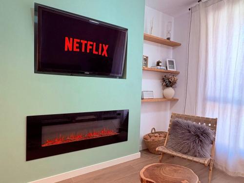a living room with a television above a fireplace at IMROF - Mountain Lodge in Escarrilla
