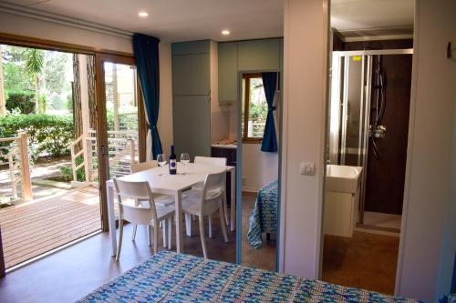 a room with a table and chairs and a bedroom at Le Esperidi Camping Ecoresort in Marina di Bibbona
