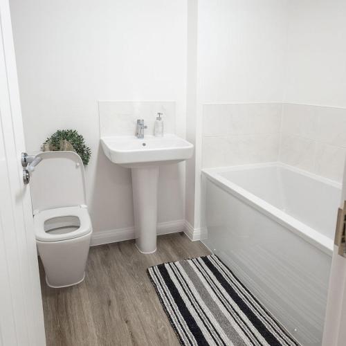 a bathroom with a sink and a toilet and a bath tub at Halton haven Three bed house sleeps 8 in Halton