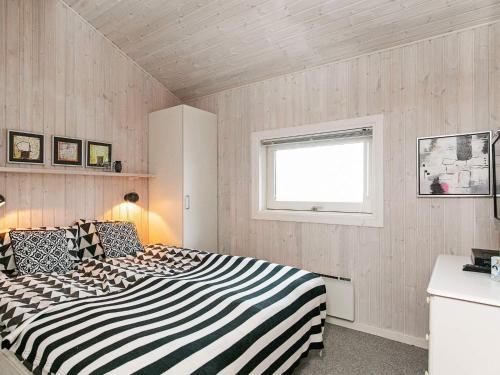 a bedroom with a black and white striped bed at 4 star holiday home in Svendborg in Svendborg