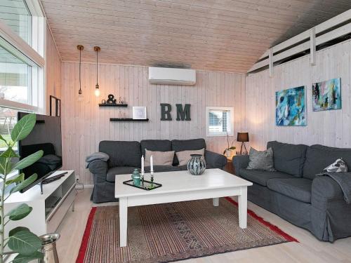 a living room with a couch and a table at 4 star holiday home in Svendborg in Svendborg