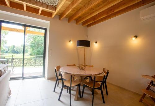 a dining room with a table and chairs and a window at La maison d'elena in Thiviers