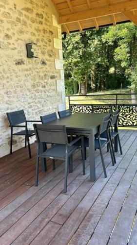 a picnic table and chairs on a wooden deck at La maison d'elena in Thiviers
