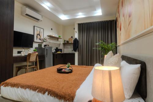 a bedroom with a bed and a table with a lamp at One Stayz by Zipcode in Gurgaon