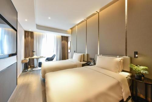 a hotel room with two beds and a television at Atour Hotel Beijing Chaoyangmen in Beijing