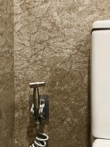 a bathroom with a toilet and a phone on a wall at Ascott IFC Guangzhou - Free Shuttle Bus For Canton Fair in Guangzhou