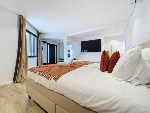 a bedroom with a large bed with a tv on the wall at Breeze House 2 by Atlantic Holiday in Garajau