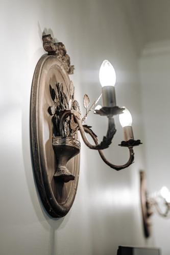 a wall mounted light with a vase on a wall at Vārves Muiža in Vārve