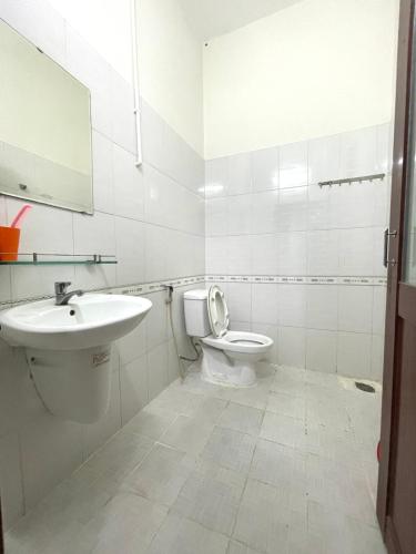a white bathroom with a sink and a toilet at Thu Đô Motel in Vung Tau