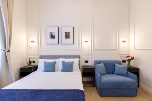 a bedroom with a bed and a blue chair at Piazza del Popolo Boutique GuestHouse in Rome