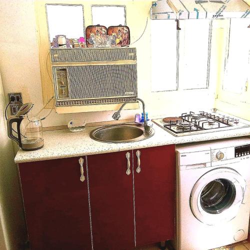 een keuken met een gootsteen en een wasmachine bij Центр in Baku