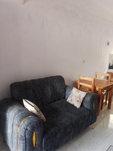 a living room with a black couch and a table at Roadstar Homes agency in Watamu