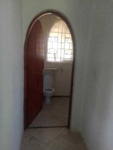 an arched doorway to a bathroom with a toilet at Roadstar Homes agency in Watamu