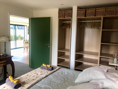 a bedroom with a bed and a green wall at Villa Tidinghi, plage de Rospico à pied in Névez