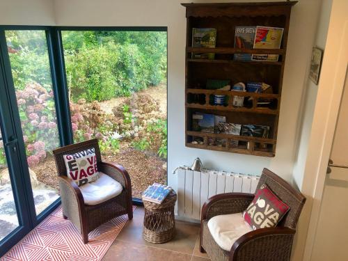 a living room with two chairs and a window at Villa Tidinghi, plage de Rospico à pied in Névez