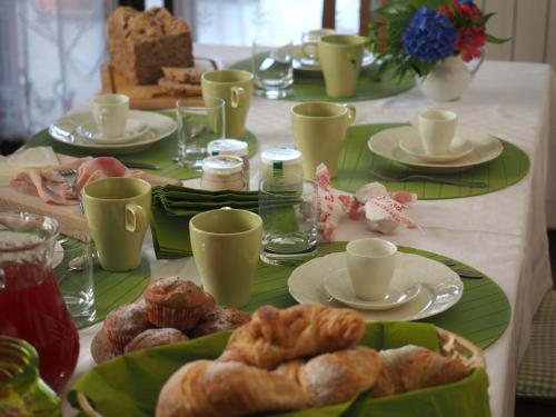 a table with cups and plates of pastries on it at Ca' Rosa Bed & Breakfast in Malnate