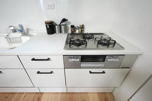 a kitchen with a stove and a white counter top at The CATAN 久美浜 in Kyotango