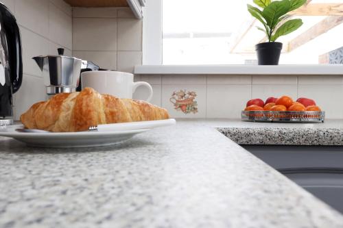 a loaf of bread on a plate on a kitchen counter at King Beds - Dining Space - Ev Charger - Coffee - Contractor & Families in Coity