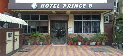 a hotel entrance with potted plants in front of it at Hotel Prince B in Guwahati